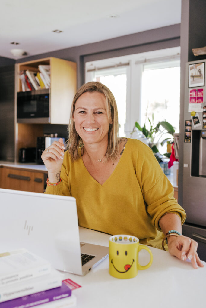 coach souriante devant son ordinateur